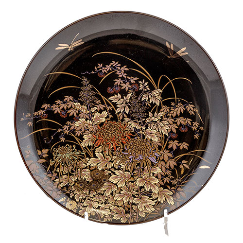 Sub.:11 - Lote: 179 -  Plato japons decorativo en porcelana negra esmaltada. Con decoracin de manto de flores y liblula. 