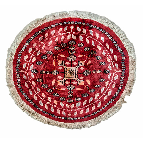 Sub.:12 - Lote: 91405 -  Pequea alfombra circular tipo persa con gol como motivo central y borde de hojas dentadas sobre fondo rojo.