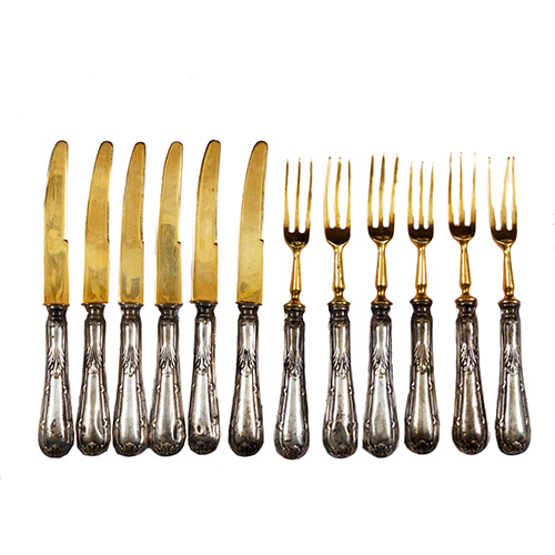 Sub.:16 - Lote: 255 -  Juego de seis cuchillos y tenedores en metal plateado y dorado, con mango cincelado. 12 piezas.