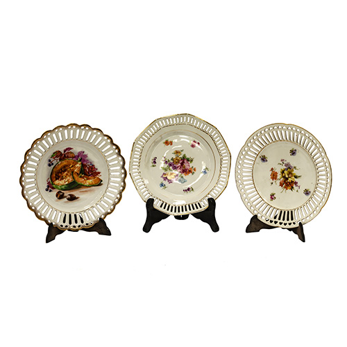 Sub.:17 - Lote: 112 -  Lote de tres platos en porcelana con ala calada y decoracin de motivos frutales. 