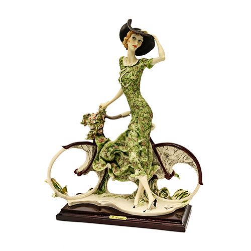 Sub.:17 - Lote: 171 -  Figura en marmolina de Capodimonte representando a mujer con bicicleta. Sobre peana. 