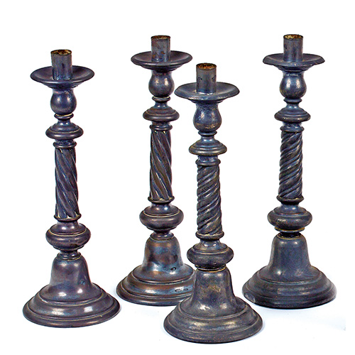 Sub.:17 - Lote: 117 -  Juego de cuatro candeleros en metal con vstagos torneados.