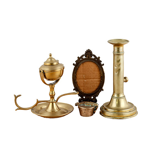 Sub.:18 - Lote: 263 -  Lote de cuatro piezas de bronce, formado por un candelero con faltas, portarretratos, palmatoria y ponderal incompleto.