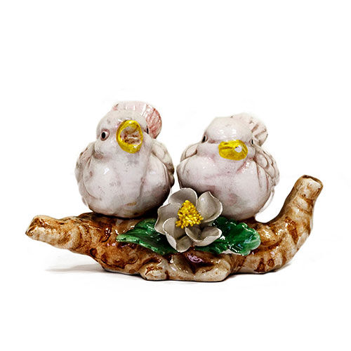 Sub.:1-On - Lote: 404 -  Figura en cermica de una pareja de pjaros sobre una rama de rbol con motivo floral en el centro.