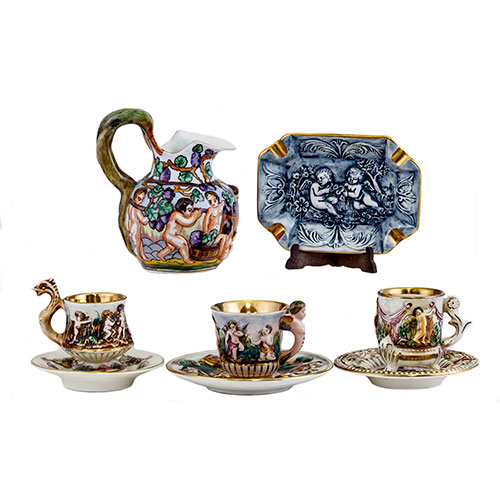 Sub.:10-On - Lote: 795 -  Lote de Jarrita y tres tazas con sus platos a juego de porcelana esmaltada con decoracin de putti y angelotes y la jarra con la vendimia.
