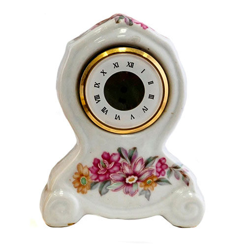 Sub.:10-On - Lote: 117 -  Pequeo reloj en porcelana esmaltada con decoracin floral y esfera con numeracin romana.
