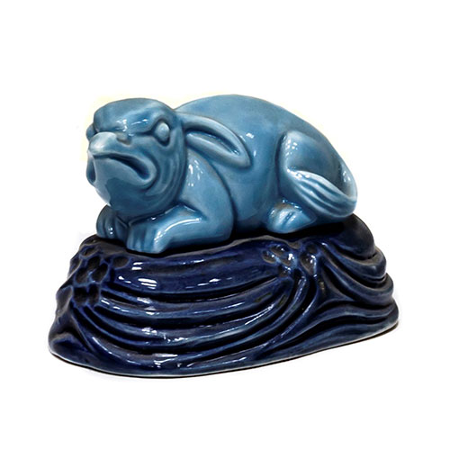 Sub.:10-On - Lote: 875 -  Figura de conejo en porcelana esmaltada azul sobre peana.