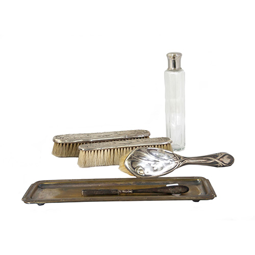 Sub.:10 - Lote: 1624 -  Restos de juegos de tocador. Con cepillo de pelo dec, bandeja en metal plateado, pinzas de depilar y frascos en cristal tallado.