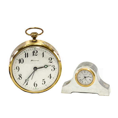 Sub.:10 - Lote: 1264 -  Lote de dos relojes uno de sobremesa en metal plateado marca Titan con esfera de numeracin romana; otro despertador, marca Blessing realizado en Alemania Occidental.