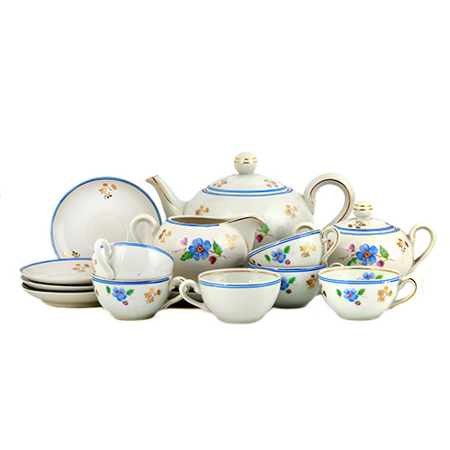 Sub.:10 - Lote: 1527 -  Juego de t en porcelana con decoracin floral en azul y dorado. De seis servicios (plato y taza), tetera y azucarero.