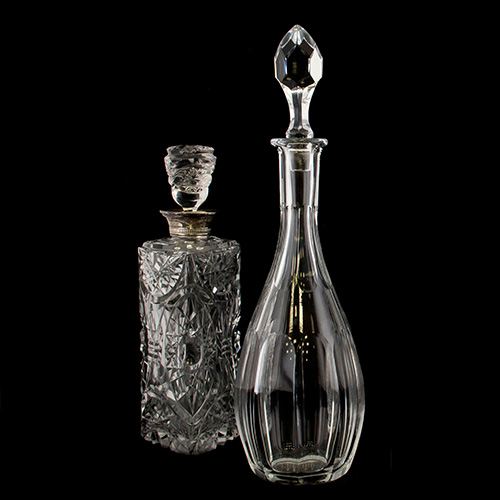 Sub.:10 - Lote: 1609 -  Dos licoreras en cristal tallado, una de ellas con embocadura de plata.