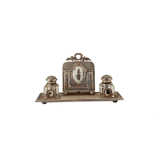 Sub.:10 - Lote: 686 -  Escribana en metal plateado con tinteros de cristal. Frontal suelto, con decoracin grabada de escudo laureado.