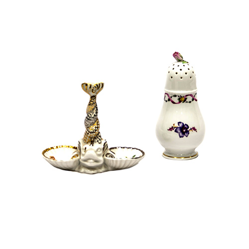 Sub.:10 - Lote: 1656 -  Lote de dos saleros en en porcelana esmaltada, uno alto, con guirnaldas y flores, coronado con una rosa; el otro en forma de entremesero con mstil en forma de pez y detalles dorados.