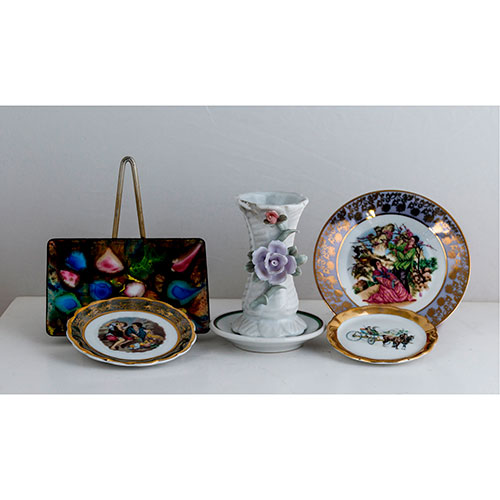 Sub.:11-On - Lote: 1126 -  Lote de sies piezas, tres platos decorados con diferentes motivos y pequeño violetero en cerámica y porcelana, y pequeña bandejita en metal esmaltado.
