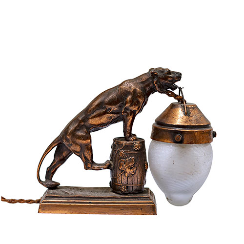 Sub.:12-On - Lote: 83 -  Lámpara de sobre mesa en calamina con forma de leona sujetando un farol.