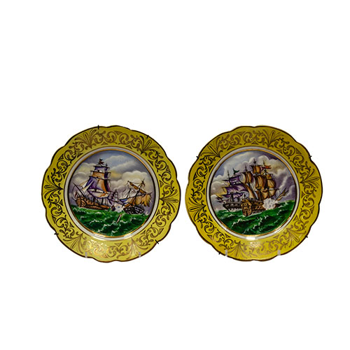 Sub.:13-On - Lote: 359 -  Pareja de platos en porcelana con imgenes de batallas navales enmarcados por orla amarilla y dorada.