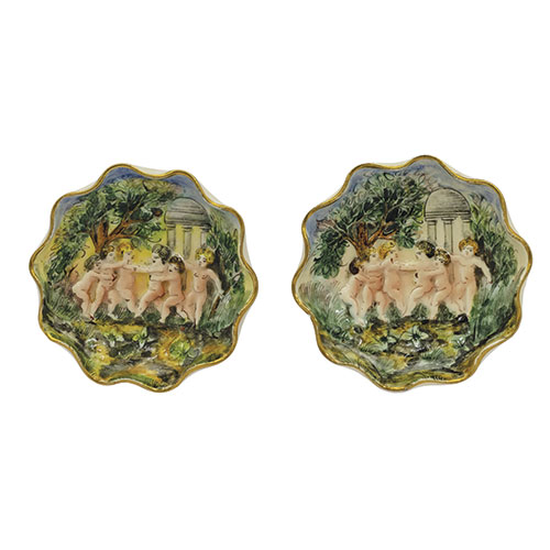 Sub.:13-On - Lote: 345 -  Dos platillos en porcelana de Capodimonte con escenas de querubines en relieve.