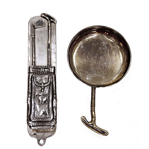 Sub.:14-On - Lote: 1664 -  Cenicero en metal plateado con agarre de palo de golf firma Valenti y pinza para notas con bolsa de palos de golf.