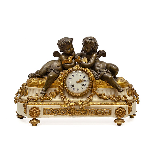 Sub.:14 - Lote: 1266 -  Reloj de sobremesa en bronce dorado, pavonado y mrmol coronada por dos puttis con aves. Esfera esmaltada con numeracin romana y minutos en arabiga. Falta pndulo. Con llave.
