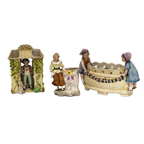 Sub.:14 - Lote: 1380 -  Lote de un centro de mesa, un violetero en biscuit y otro en porcelana con figuras de nios.