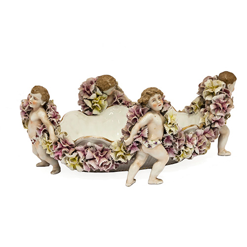 Sub.:17 - Lote: 1183 -  Centro de mesa en porcelana policromada con nios en los extremos cubiertos de flores en relieve.