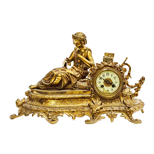 Sub.:18 - Lote: 336 -  Reloj en bronce dorado con figura recostada leyendo, esfera en esmalte con numeracin arbiga. Desperfectos en la esfera. Con pndulo y llave.
