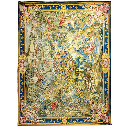 Sub.:18 - Lote: 346 -  Gran alfombra de lana y seda con escudo central rodeado de flores y cuatro escenas cinegticas a la manera del siglo XVIII. Borde perimetral con flores de lis. Stuyck
