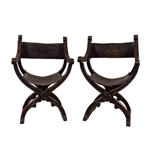 Sub.:18 - Lote: 1359 -  Pareja de jamugas en madera de nogal tallada, rematadas con cabezas de le�n. Tapicer�a en cuero, asiento con motivos de granadas grabados, y respaldo con representaci�n de �guila bic�fala con escudo de armas. Uno de los asientos de cuero para restaurar.