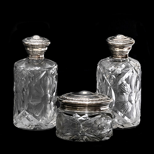 Sub.:19 - Lote: 1437 -  Lote de tres objetos: dos frascos y un bote, realizados en cristal tallado con boca en plata.