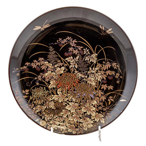 Sub.:2-On - Lote: 780 -  Plato japons decorativo en porcelana negra esmaltada. Con decoracin de manto de flores y liblula. Sello en la parte posterior.
