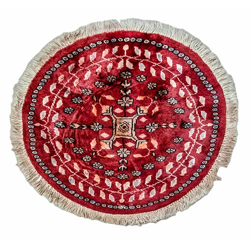 Sub.:2-On - Lote: 261 -  Pequea alfombra circular tipo persa con gol como motivo central y borde de hojas dentadas sobre fondo rojo.