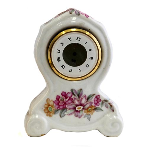 Sub.:2-On - Lote: 961 -  Pequeo reloj en porcelana esmaltada con decoracin floral y esfera con numeracin romana.