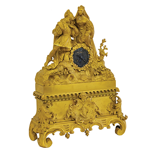 Sub.:20 - Lote: 479 -  Reloj de sobremesa en bronce con esfera para cambiar. Escena central de pareja adornado con motivos florales.