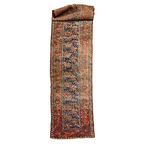 Sub.:22 - Lote: 1281 -  Alfombra persa de pasillo en lana tonos azul y rojo. Cenefa decorada con herati y zarcillos de flores, con desgastes.