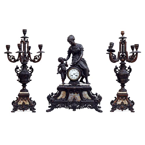Sub.:22 - Lote: 342 -  Guarnici�n de reloj en calamina y m�rmol blanco. Figura de mujer con ni�o y candelabros de cinco luces.