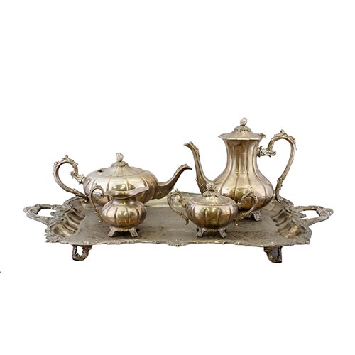 Sub.:22 - Lote: 1269 -  Juego de caf� y t�, con bandeja en metal plateado. Bandeja con dos asas fondo grabado con temas florarles y vegetales. Cafetera, tetera, lechera y acuzarera, de cuerpo lobulado y tapas rematadas con semillas de cacao.
