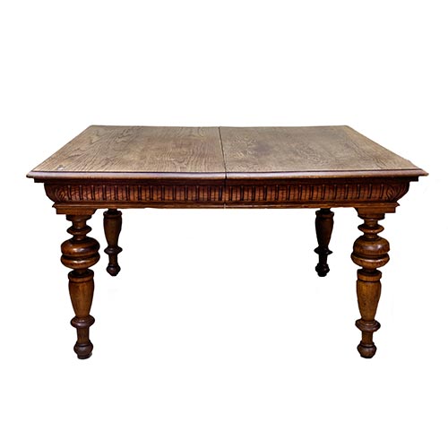Sub.:22 - Lote: 1167 -  Mesa de comedor en madera de roble, tablero supletorio en madera de pino con borde tallado y patas torneadas. Falta el pie central.