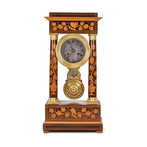 Sub.:25 - Lote: 422 -  Reloj de columnas en madera con motivos en marquetera, S.XIX. Con pndulo y llave.