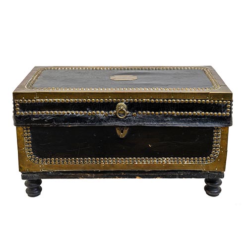 Sub.:25 - Lote: 1298 -  Peque�o ba�l encorado con refuerzos perimetrales en lat�n y tachuelas. Apoya sobre patas torneadas de madera. S.XIX