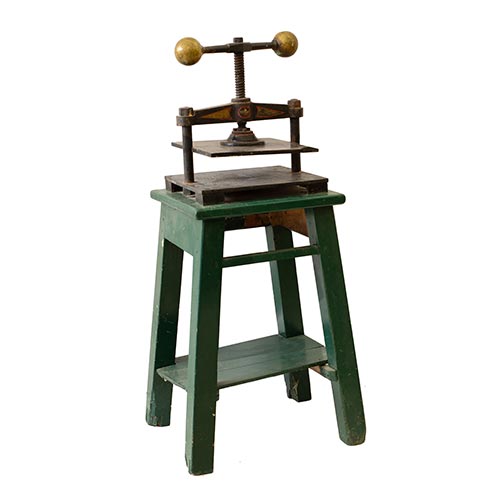 Sub.:25 - Lote: 356 -  Prensa de mano en hierro y bronce con mesa en madera pintada de verde.
