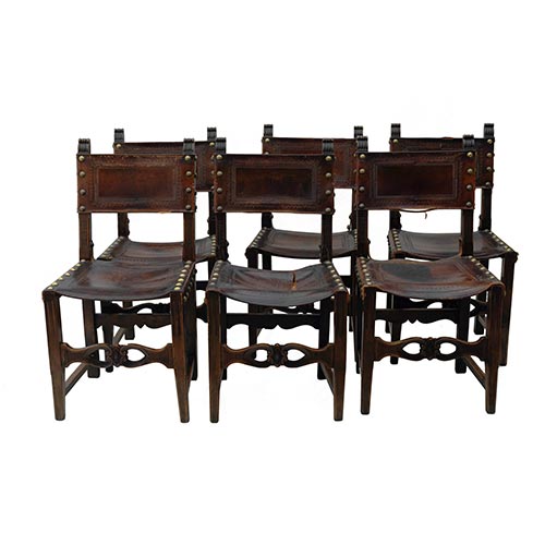 Sub.:25 - Lote: 1596 -  Lote de seis sillas estilo Renacimiento en madera tallada con asiento y respaldo en cuero y tachuelas. Principios s. XX.