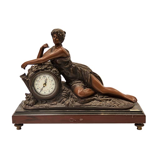 Sub.:26 - Lote: 1360 -  Reloj de sobremesa en resina con figura de dama sobre peana de madera.