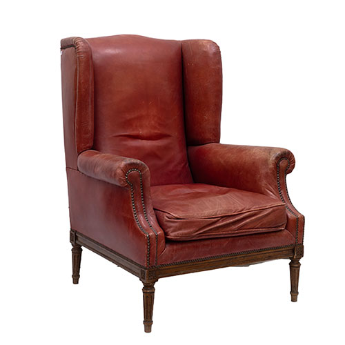 Sub.:32 - Lote: 1388 -  Sill�n orejero en cuero granate con patas en madera tallada de estilo Luis XVI.