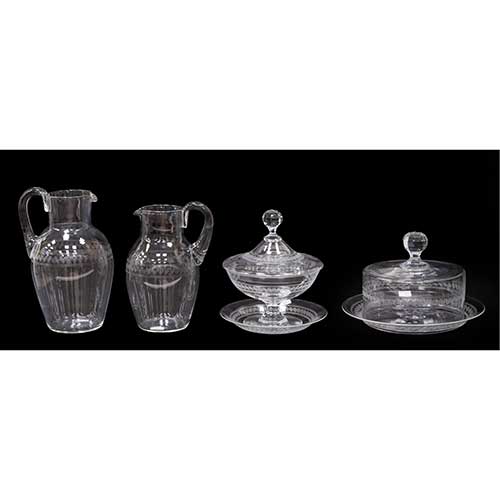 Sub.:34 - Lote: 306 -  Lote de cuatro piezas de cristal con greca grabada: 2 jarras de diferentes medidas, 1 quesera y 1 compotera con plato.