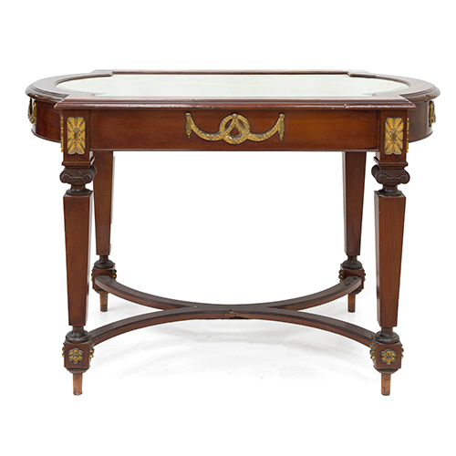 Sub.:38 - Lote: 1464 -  Mesa velador en madera de caoba con aplicaciones de bronce y tapa de cristal.