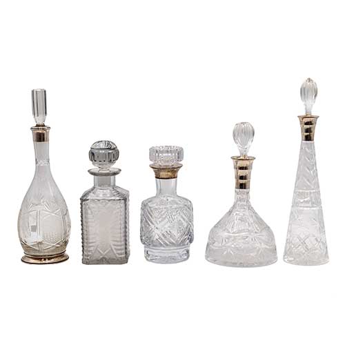 Sub.:40 - Lote: 338 -  Cinco licoreras en cristal tallado con embocaduras en plata.