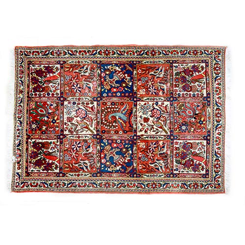 Sub.:7-On - Lote: 309 -  Alfombra estilo persa de tipo jard�n, s. XX. Ell campo central queda dividido en un entramado de cuadr�cula en el que se distribuyen diversas escenas orientadas con motivos florales, quedando la representaci�n de un pavo real en el centro. Los perfiles se recortan sobre fondos de distintos colores de gama c�lida a excepci�n de los dos cuadrados que enmarcan el central y cuyas figuras se recortan sobre fondo azul. La orla exterior remata con una guirnalda de motivos estilizados sobre fondo blanco. Reformula motivos de la tradici�n persa, y, en concreto, la disposici�n de las alfombras de jard�n, con una simbolog�a muy concreta asociada al Para�so isl�mico, y que origina este tipo de composici�n relativamente tard�a y de procedencia persa. Su trama busca la imitaci�n de los jardines de los sah, divididos en parcelas rectangulares o cuadradas por alamedas y canales de irrigaci�n (chahar bagh).