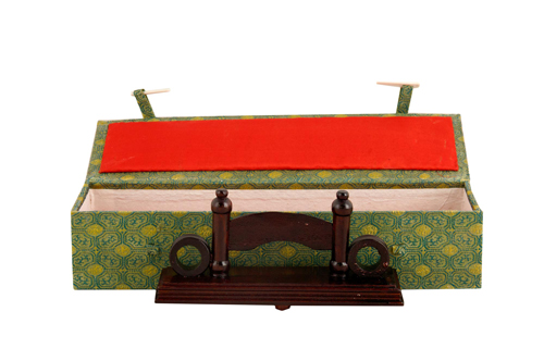 Sub.:7 - Lote: 501 -  Caja recubierta de tela en color verde con pequea figura de madera en el interior.