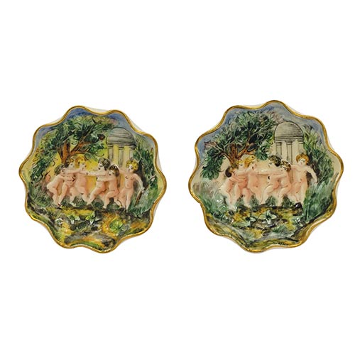 Sub.:8-On - Lote: 367 -  Dos platillos en porcelana de Capodimonte con escenas de querubines en relieve.