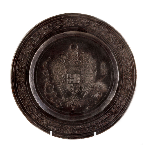 Sub.:8 - Lote: 3433 -  Plato en metal con decoraci�n en el asiento del escudo de Espa�a y alero con motivos de vides.